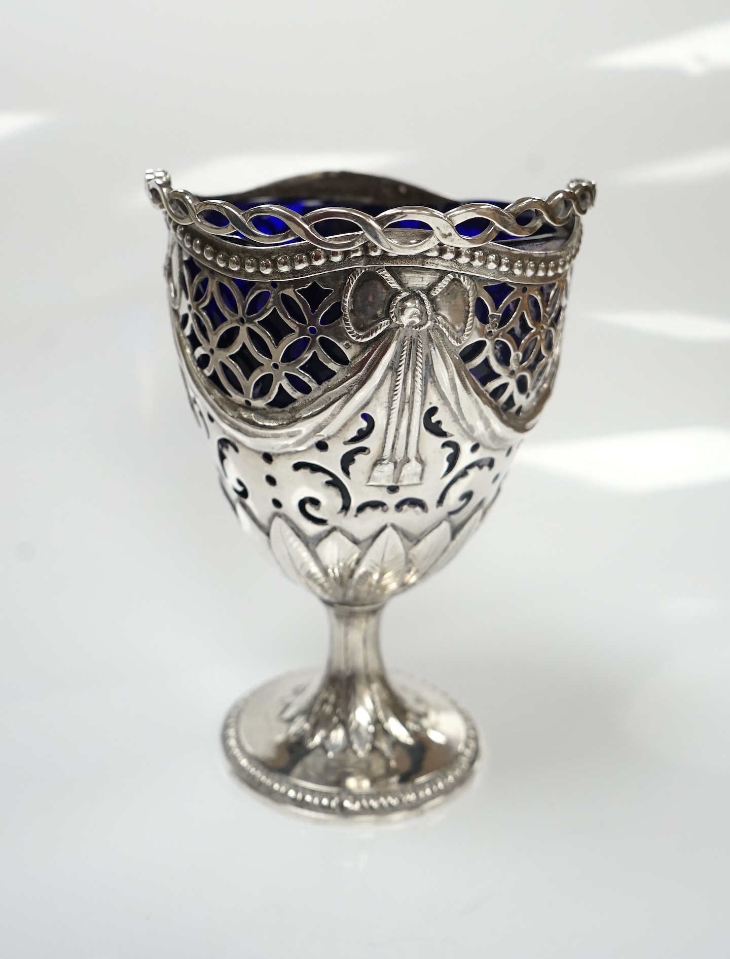 A George III silver pedestal sugar basket, with blue glass liner, indistinct marks, height 12.4cm. Condition - fair